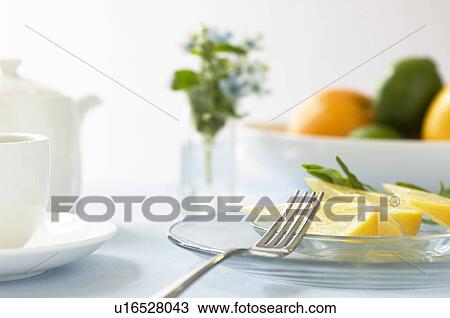 Stock Image - Grapefruit slice on table setting. Fotosearch