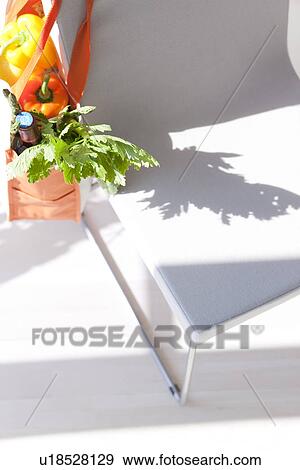 Groceries in an eco-bag hanging on a chair View Large Photo Image Stock Photo - Groceries in an eco-bag hanging on a chair. Fotosearch