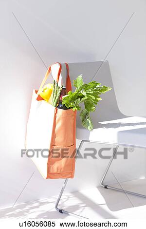 Stock Photography - Groceries in an eco-bag hanging on a chair. Fotosearch