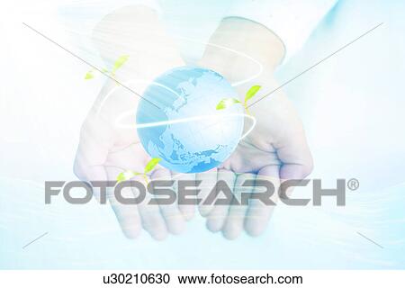 Stock Image - Hands holding the world surrounded by leaves. Fotosearch