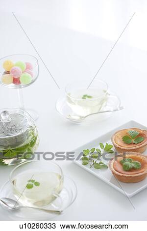 Herbal tea, a glass of candy and tarts View Large Photo Image Stock Image - Herbal tea, a glass of candy and tarts. Fotosearch