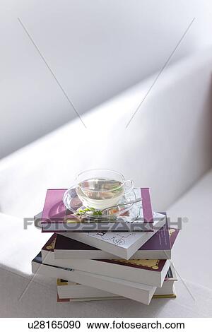 Herbal tea and a pile of books on a sofa View Large Photo Image Stock Image - Herbal tea and a pile of books on a sofa. Fotosearch