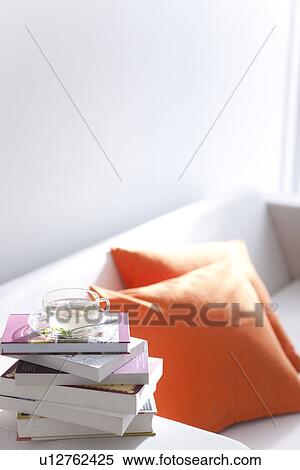 Stock Photography - Herbal tea and a pile of books on a sofa. Fotosearch