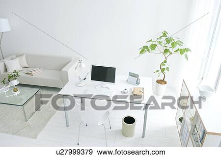 Stock Photo - Home office in living room with potted plant. Fotosearch