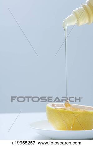 Honey being poured onto a grapefruit View Large Photo Image Stock Photo - Honey being poured onto a grapefruit. Fotosearch