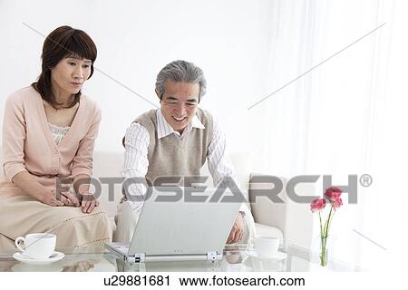 Husband and wife using a laptop View Large Photo Image Stock Image - Husband and wife using a laptop. Fotosearch
