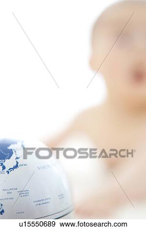 Stock Photo - Inflatable globe and a baby in the background. Fotosearch