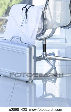 Stock Image - Lab coat and stethoscope draped over a chair. Fotosearch