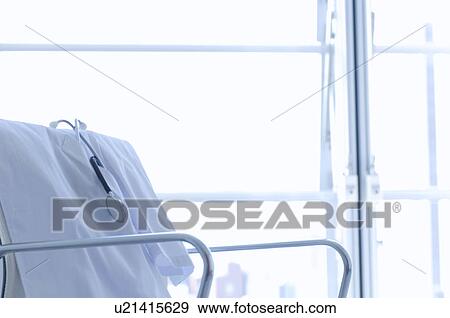 Stock Photo - Lab coat and stethoscope draped over a chair. Fotosearch