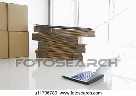 Stock Image - Laptop and cardboard boxes. Fotosearch