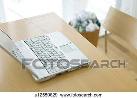 Stock Photo - Laptop computer on desk near wastepaper bin. Fotosearch