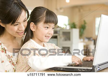 Little girl and her mother using laptop in a cafe View Large Photo Image Stock Image - Little girl and her mother using laptop in a cafe. Fotosearch