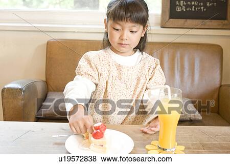 Stock Photo - Little girl eating strawberry cake. Fotosearch