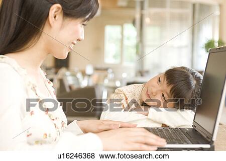 Little girl gazing at her mother using laptop in a cafe View Large Photo Image Stock Photo - Little girl gazing at her mother using laptop in a cafe. Fotosearch