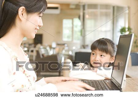 Little girl gazing at her mother using laptop in a cafe View Large Photo Image Stock Photo - Little girl gazing at her mother using laptop in a cafe. Fotosearch