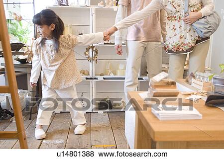 Stock Photo - Little girl leading mother by the hand on a shopping trip with her parents. Fotosearch