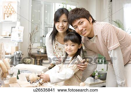 Stock Image - Little girl looking at knick knacks with parents. Fotosearch