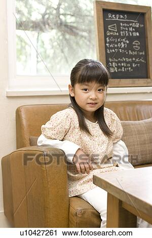 Little girl sitting on sofa in cafe View Large Photo Image Stock Image - Little girl sitting on sofa in cafe. Fotosearch