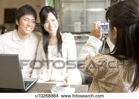Picture - Little girl taking photo of her parents. Fotosearch