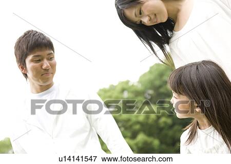 Stock Photo - Little girl walking with her parents. Fotosearch