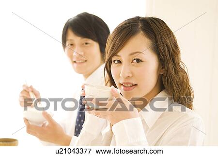 Stock Photo - Man and woman eating meal at dining table. Fotosearch