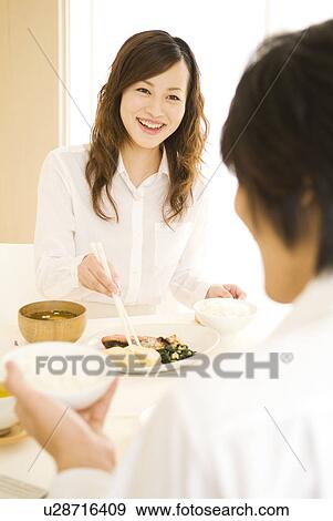 Stock Photo - Man and woman sitting eating meal. Fotosearch