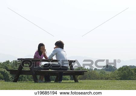 Man and woman sitting together at picnic table View Large Photo Image Picture - Man and woman sitting together at picnic table. Fotosearch