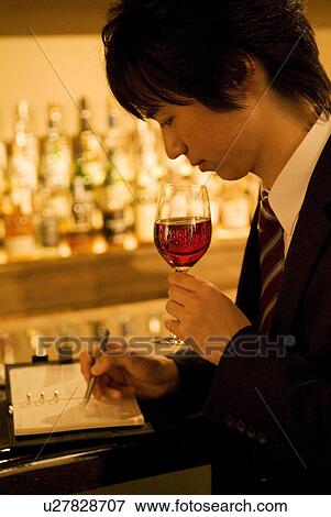 Stock Photo - Man drinking wine and writing in his business diary. Fotosearch