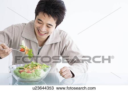 Stock Image - Man eating salad. Fotosearch
