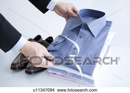 Picture - Man folding shirts. Fotosearch