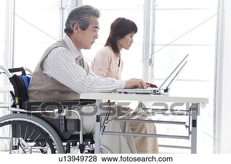 Stock Photo - Man in wheelchair and woman studying. Fotosearch