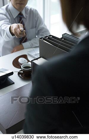 Stock Image - Man pointing at woman in office. Fotosearch
