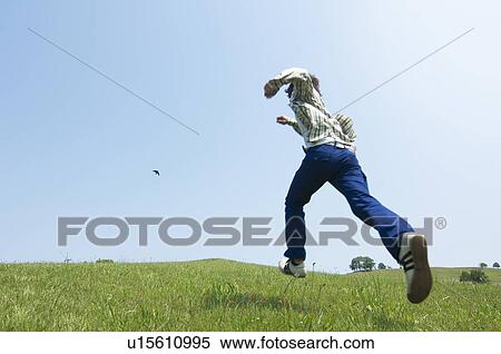 Stock Photography - Man running on grass. Fotosearch