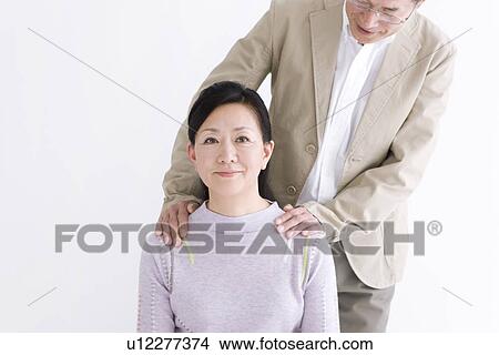 Picture - Man standing behind his wife. Fotosearch