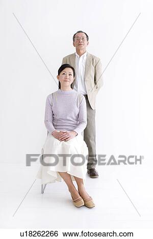 Stock Photograph - Man standing behind his wife. Fotosearch