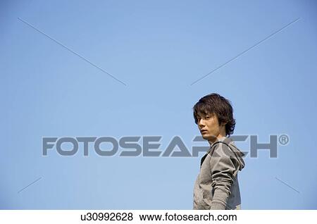 Stock Photo - Man standing looking at camera. Fotosearch