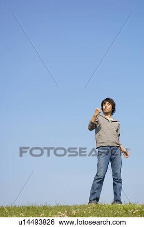 Man standing on grass clenching fist View Large Photo Image Stock Photograph - Man standing on grass clenching fist. Fotosearch