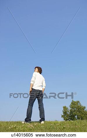 Man standing on grass gazing into distance View Large Photo Image Stock Photography - Man standing on grass gazing into distance. Fotosearch