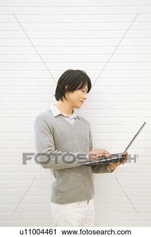 Man using his laptop View Large Photo Image Stock Image - Man using his laptop. Fotosearch