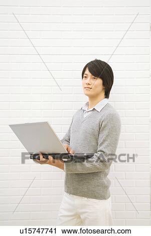 Stock Image - Man using his laptop. Fotosearch