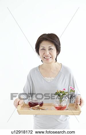 Mature woman carrying a tray of food and tea View Large Photo Image Stock Image - Mature woman carrying a tray of food and tea. Fotosearch