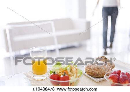 Stock Photo - Meal of salad, strawberries and bread rolls and a glass of juice. Fotosearch