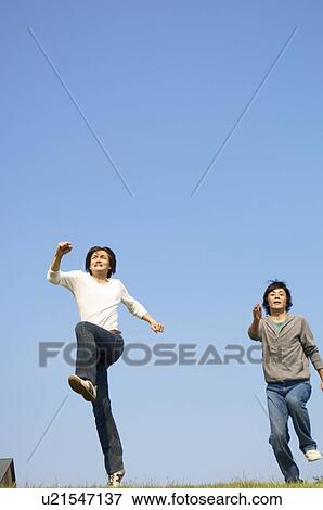 Stock Photo - Men running on grass. Fotosearch