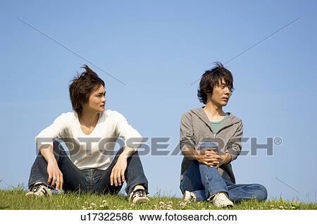 Men sitting on grass View Large Photo Image Stock Photograph - Men sitting on grass. Fotosearch
