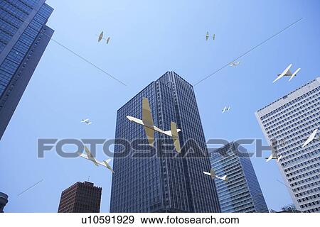 Stock Photo - Model airplanes flying around office buildings. Fotosearch