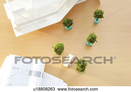 Stock Image - Model trees with building plans and model building. Fotosearch
