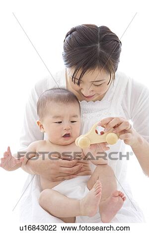 Stock Image - Mother and baby boy playing with toy car. Fotosearch
