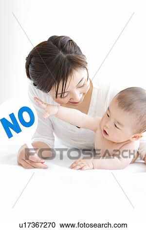 Stock Image - Mother and baby boy with sign reading 'no'. Fotosearch