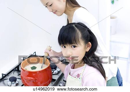 Stock Photo - Mother and daughter cooking soup. Fotosearch