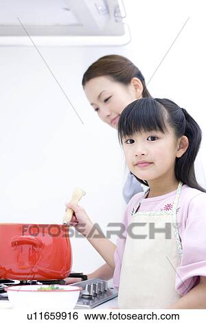 Stock Photograph - Mother and daughter cooking soup. Fotosearch